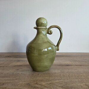 Olive green ceramic olive jar with lid.